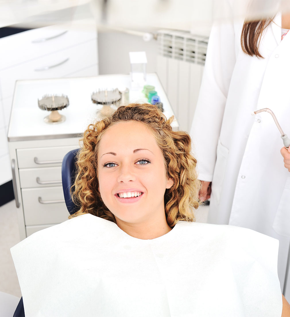 woman receiving general dentistry smiling from dental chair