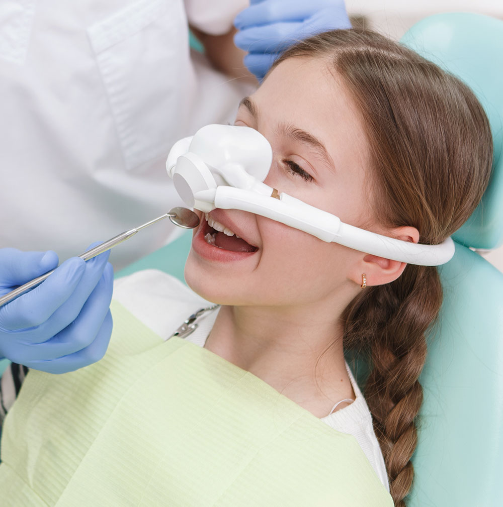 young girl receiving nitrous oxide sedation during dental treatment